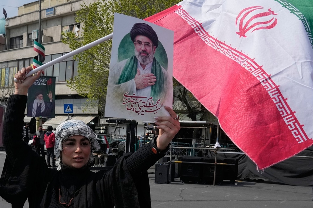 Người dân giơ cao ảnh của Lãnh tụ tối cao Iran Mojtaba Khamenei trong cuộc tuần hành ủng hộ chính phủ tại quảng trường Enqelab-e-Eslami (Cách mạng Hồi giáo).