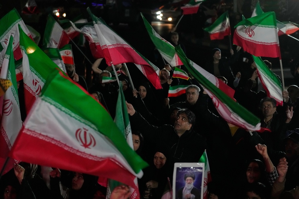 Những người ủng hộ chính phủ hô khẩu hiệu và vẫy cờ Iran trong cuộc tuần hành tại quảng trường ở phía tây Tehran, Iran.