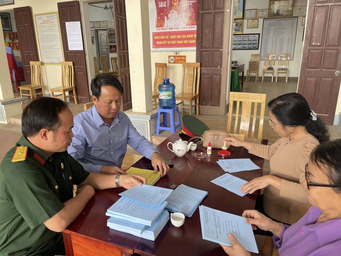 Người dân theo dõi danh sách cử tri được niêm yết công khai tại khu dân cư.