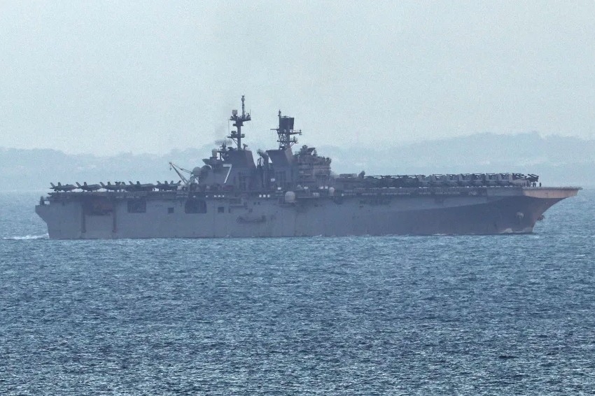 Tàu tấn công đổ bộ USS Tripoli (LHA-7) di chuyển vào eo biển Singapore ngày 17/3. Ảnh: Reuters