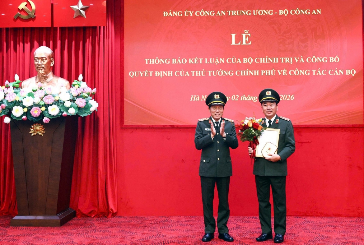 Bộ trưởng Bộ Công an, Đại tướng Lương Tam Quang trao quyết định và tặng hoa Thượng tướng Trần Quốc Tỏ. 