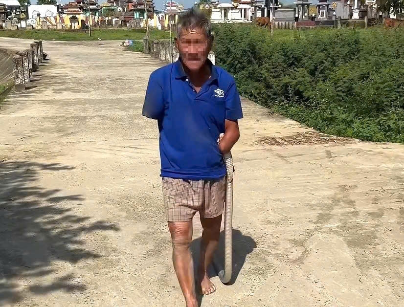 Hình ảnh cụ ông kẹp con gắn đi trên đường. Ảnh cắt từ clip.