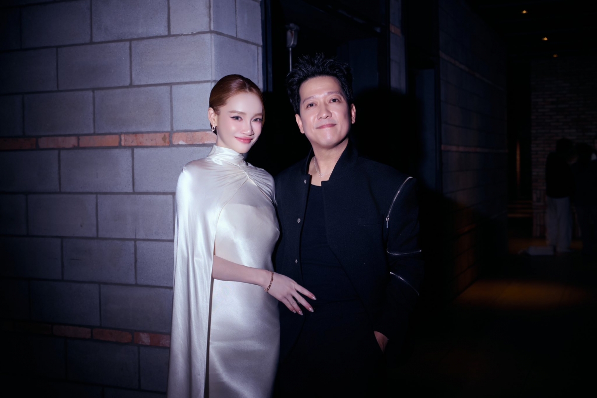 Tại buổi ra mắt phim Tết "Nhà ba tôi một phòng" của ông xã Trường Giang, Nhã Phương cũng xuất hiện để chúc mừng chồng, dù cô mới sinh con thứ ba chưa đầy một tháng. Nữ diễn viên lựa chọn thiết kế lụa trắng ôm dáng, kết hợp phần áo choàng liền thân và tà dài phía sau. Gương mặt của người đẹp giữ được nét thon gọn, rạng rỡ, gần như không lộ dấu hiệu mệt mỏi sau sinh.