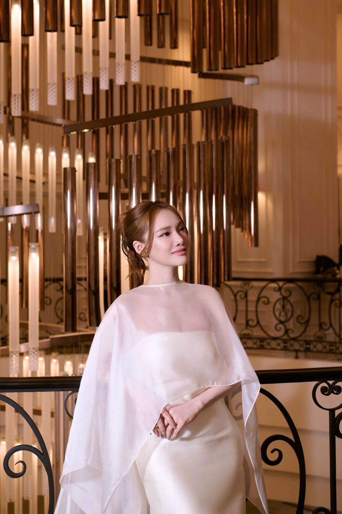 Tại một sự kiện vào tháng 3/2026, Nhã Phương lựa chọn đầm voan, lụa màu trắng với thiết kế mềm mại và bay bổng. Trang phục ôm nhẹ phần eo, tôn lên vòng hai thon gọn cùng vóc dáng mảnh mai sau sinh của nữ diễn viên. 