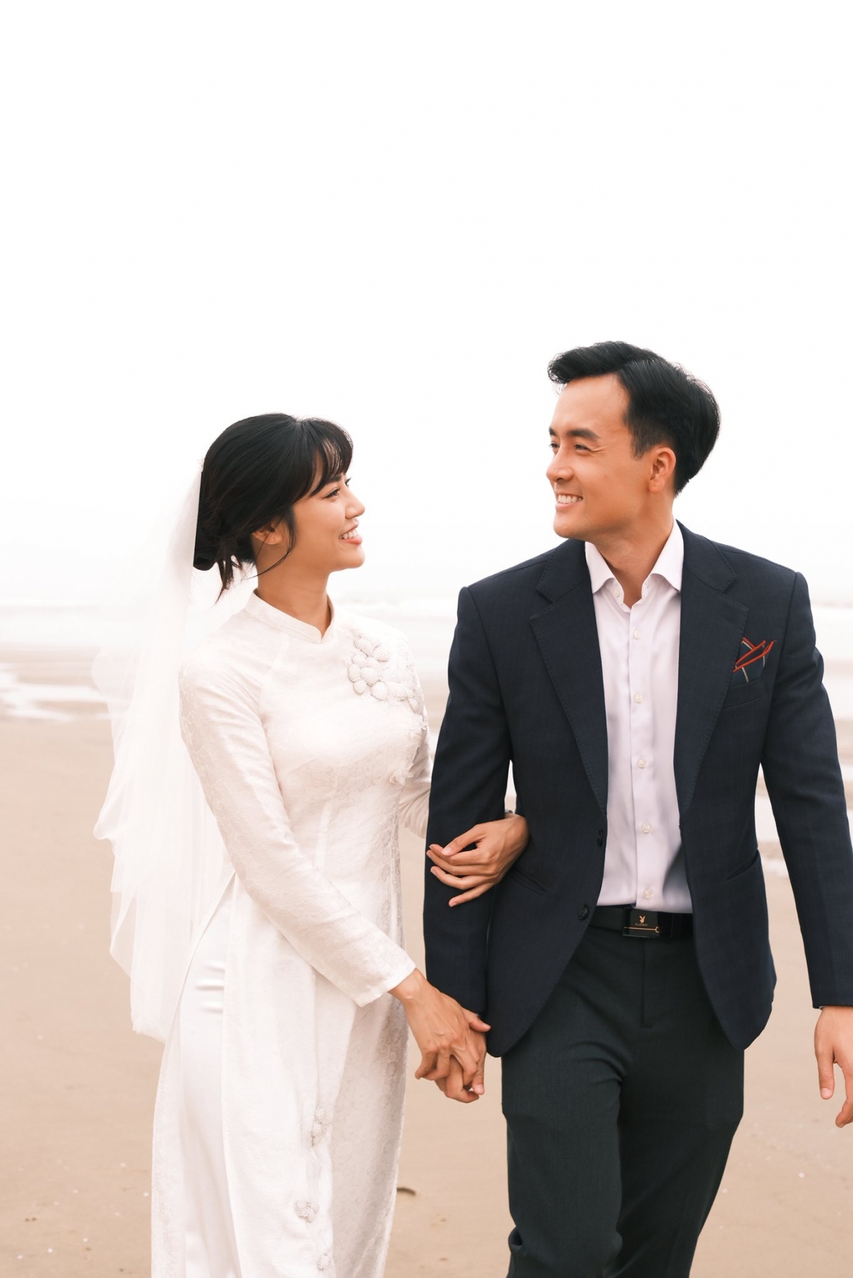 Trong loạt ảnh, Anh Đào diện áo dài cưới trắng tinh khôi, còn Anh Tuấn bảnh bao với vest và sơ mi.