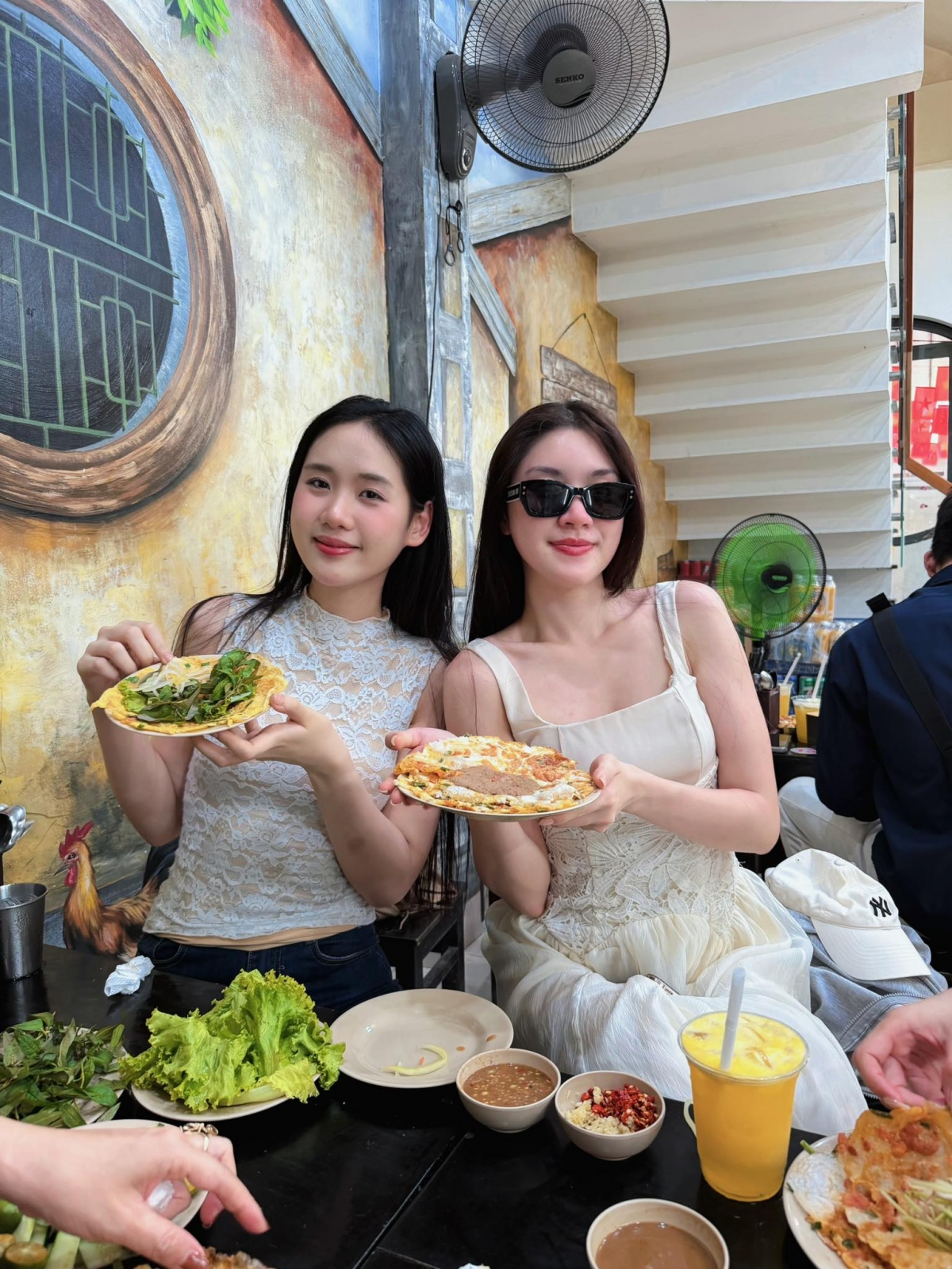 Hoa hậu Phương Oanh và Á hậu Tâm Như thưởng thức bánh ép tại Huế.