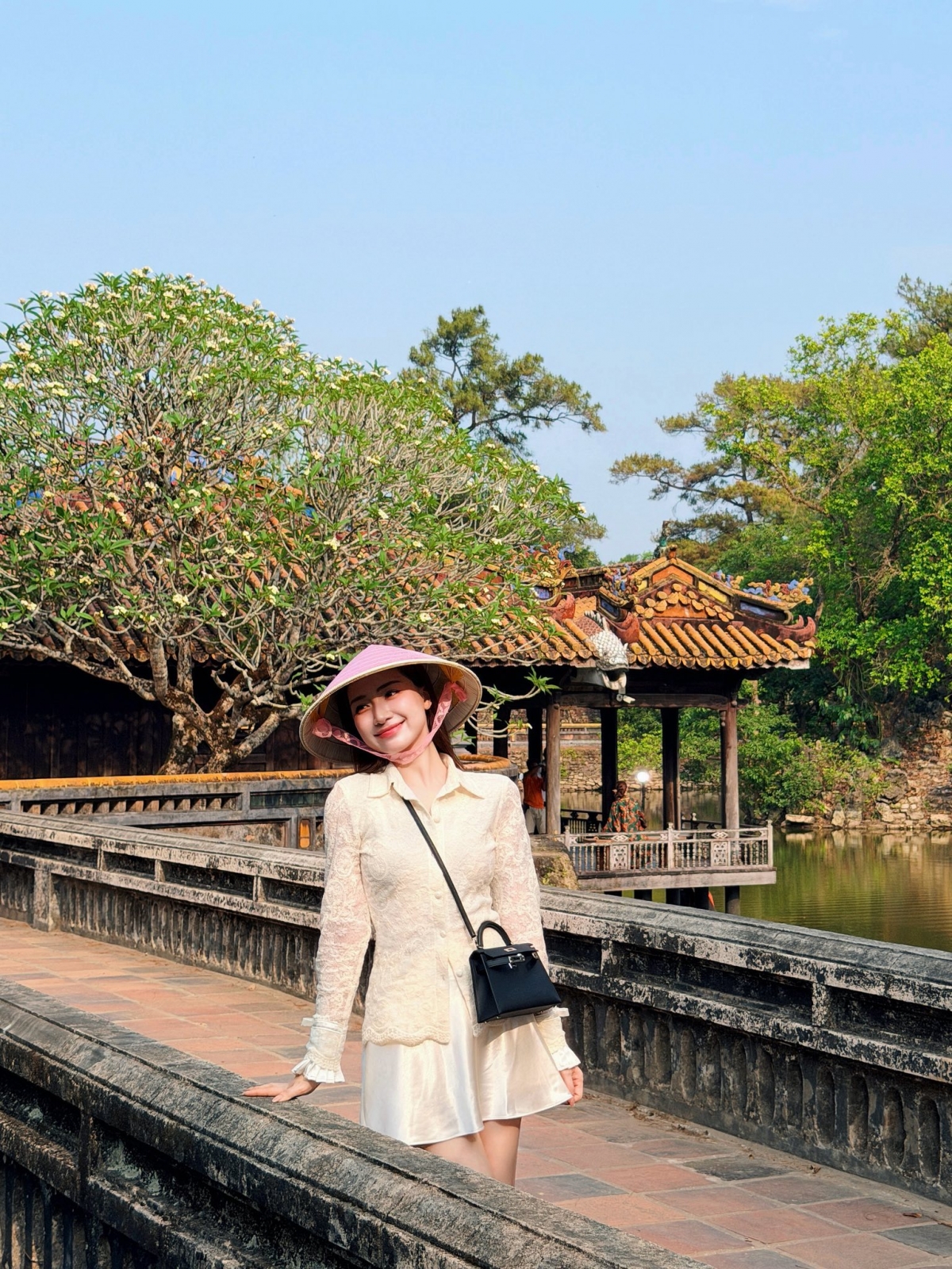 Trước đó, Hòa Minzy chia sẻ loạt ảnh đi du lịch Huế. Nữ ca sĩ đội nón lá, diện trang phục màu trắng, ghé thăm Đại Nội, lăng Tự Đức, cung An Định... Con trai Hòa Minzy - bé Bo và bạn trai cô là Đại úy Thăng Văn Cương cũng xuất hiện trong loạt ảnh.