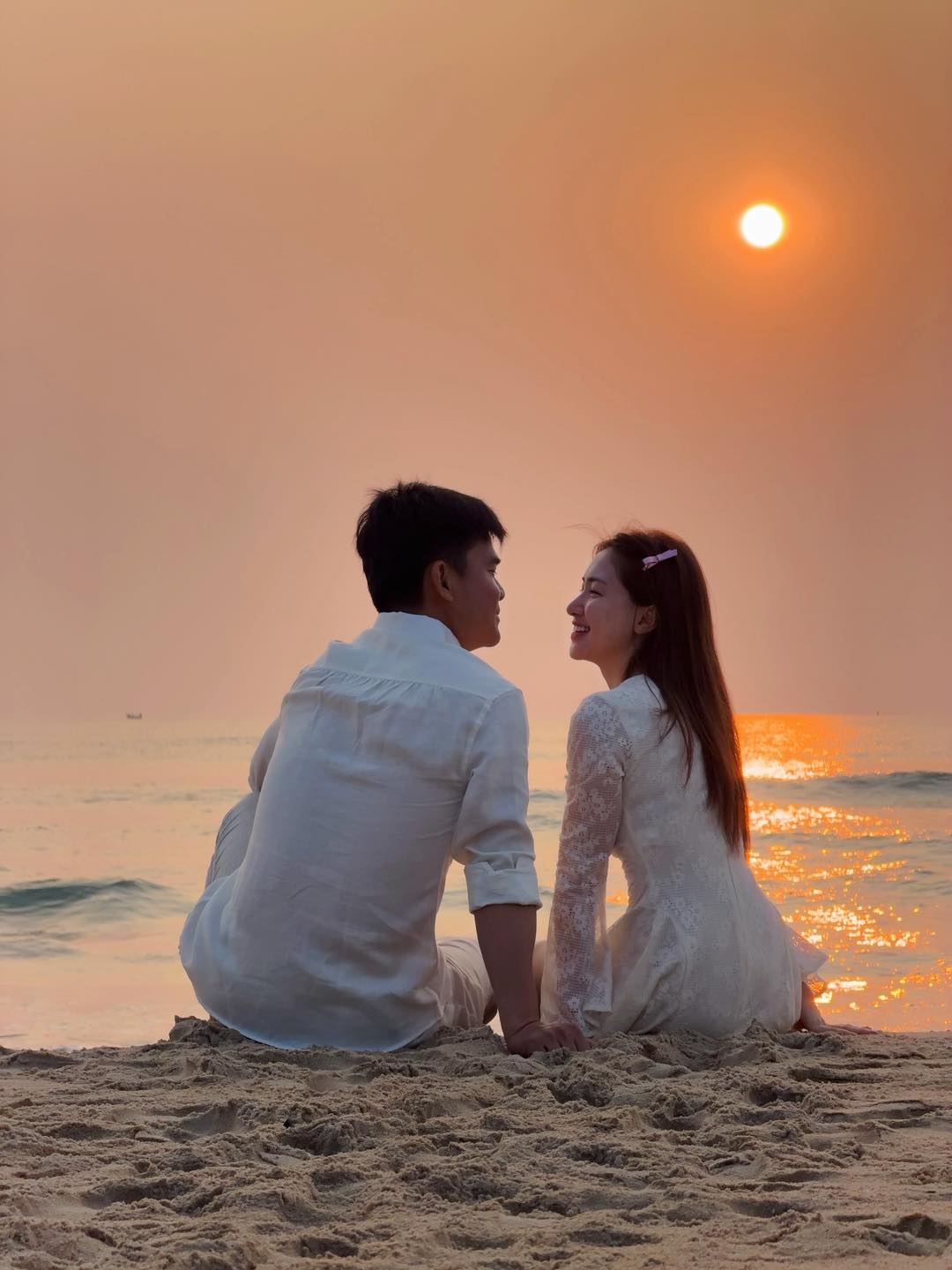 Trên trang cá nhân, Hòa Minzy đăng loạt ảnh tình tứ đón bình minh bên bạn trai quân nhân - Đại úy Thăng Văn Cương bên bờ biển Đà Nẵng. Nữ ca sĩ diện váy trắng ren nữ tính, trong khi bạn trai lựa chọn áo sơ mi cùng tông màu.