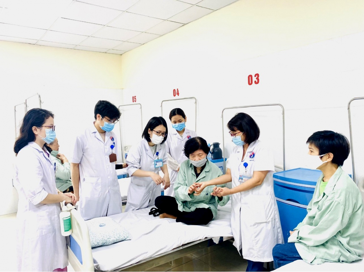 BS cao cấp, BSCKII Đỗ Thị Minh Nghĩa - Trưởng khoa Da liễu, Bệnh viện Y học cổ truyền Trung ương (thứ hai, bên phải) đang khám bệnh về da cho bệnh nhân được điều trị tại Bênh viện. Ảnh: NVCC