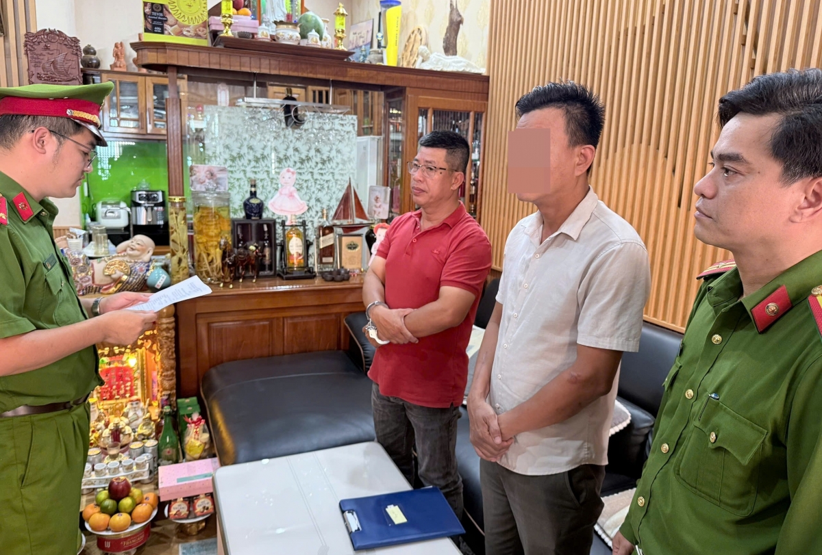 Cơ quan Cảnh sát điều tra Công an TP Đà Nẵng tống đạt các quyết định đối với Nguyễn Lê Duy Dũng (áo đỏ)