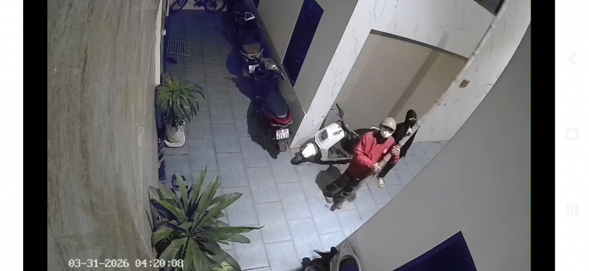 Sau đó, thanh niên áo đỏ đứng dưới, giữ cây tre để thanh niên áo đen trèo lên, đột nhập vào nhà anh P.  (Ảnh: Trích xuất camera)