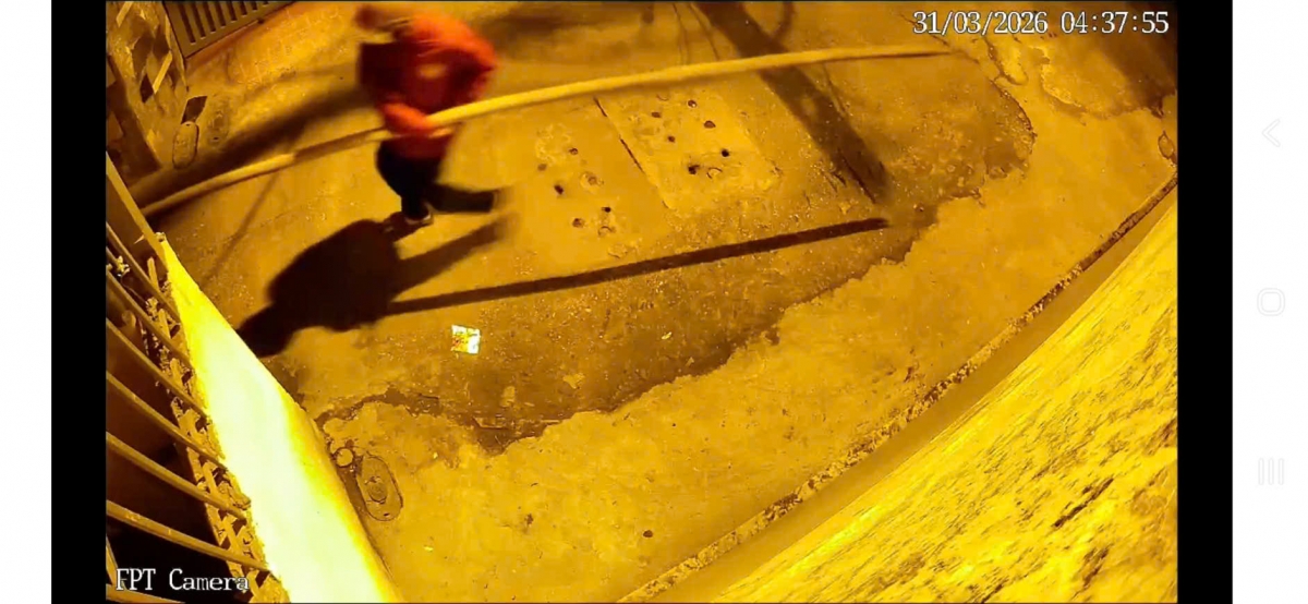 Đối tượng áo đỏ vác một cây tre dài khoảng 4m từ đầu ngõ vào. (Ảnh: Trích xuất camera)