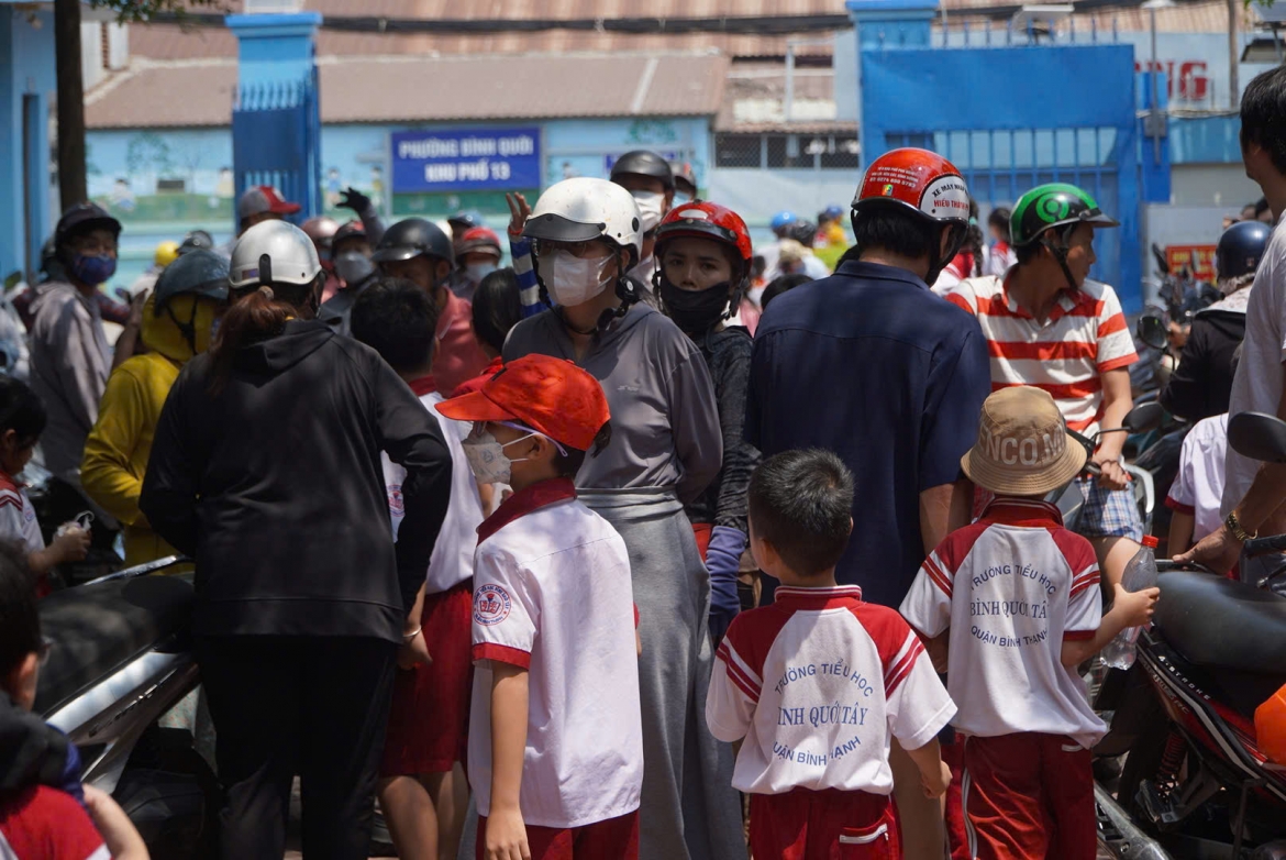 Học sinh trường Tiểu học Bình Quới Tây được cha mẹ đón về sau khi dừng bữa ăn bán trú  (ảnh: C.P)