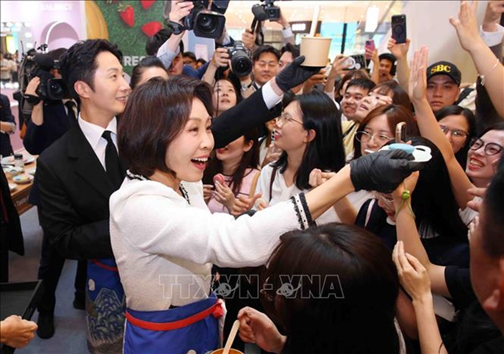 Phu nhân Tổng thống Hàn Quốc Lee Jae Myung, bà Kim Hae Kyung tặng những chiếc bánh vừa làm cho khách dự Lễ hội. Ảnh: Phạm Kiên/TTXVN