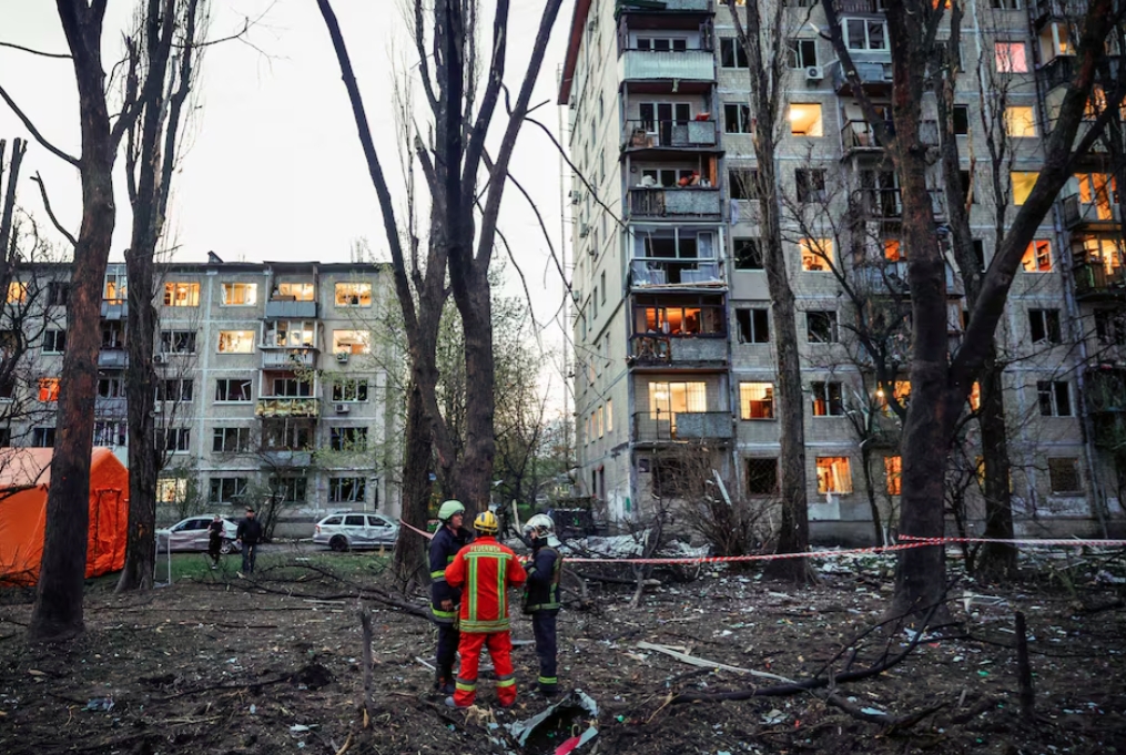 Lực lượng cứu hộ đứng gần các tòa nhà dân cư bị hư hại tại hiện trường vụ tấn công tên lửa của Nga, trong bối cảnh Nga tấn công Kiev, Ukraine, ngày 16/4/2026. Ảnh: Reuters