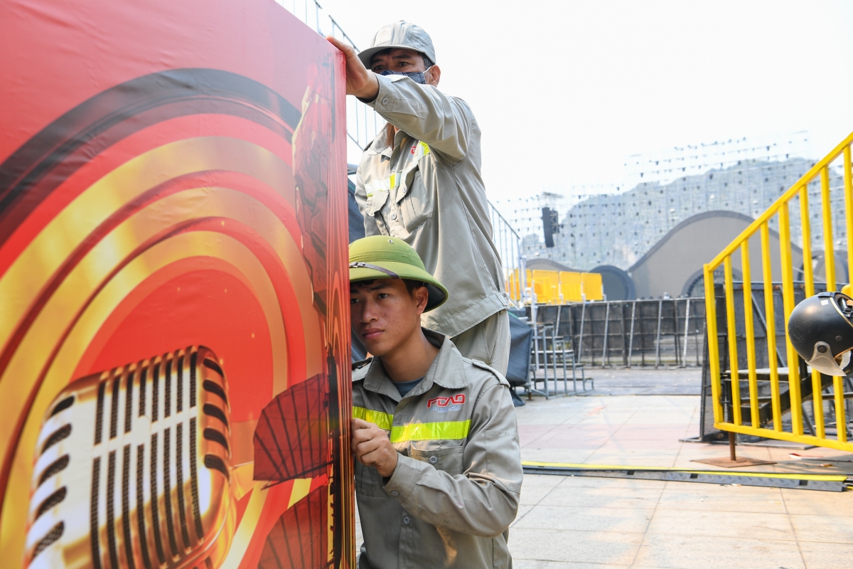 Đó là quá trình lao động nghiêm túc, sáng tạo, nơi mỗi âm thanh, mỗi câu chữ đều được chăm chút để chạm tới cảm xúc người nghe. (Ảnh: Công nhân thực hiện những khâu cuối trước giờ khai mạc)