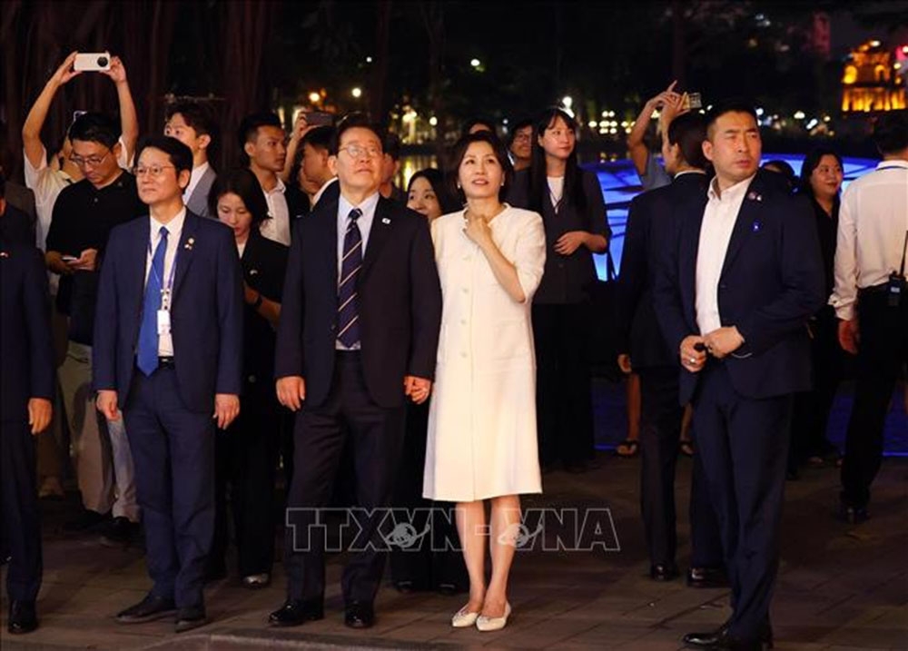 Tổng thống Hàn Quốc Lee Jae Myung và Phu nhân Kim Hae Kyung có những phút giây thư giãn bên hồ Hoàn Kiếm. Ảnh: Phạm Kiên/TTXVN
