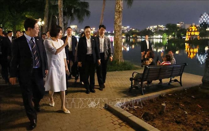 Tổng thống Hàn Quốc Lee Jae Myung và Phu nhân Kim Hae Kyung vẫy chào người dân Thủ đô bên hồ Hoàn Kiếm. Ảnh: Phạm Kiên/TTXVN