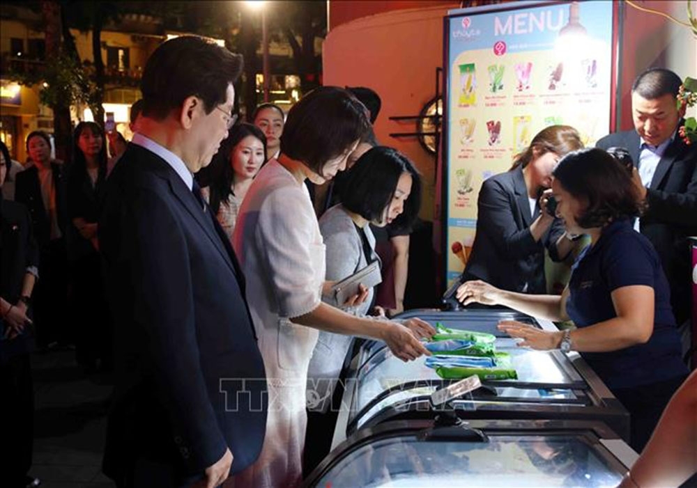 Tổng thống Hàn Quốc Lee Jae Myung và Phu nhân Kim Hae Kyung dừng chân mua kem Thủy Tạ tại khu vực hồ Hoàn Kiếm. Ảnh: Phạm Kiên/TTXVN