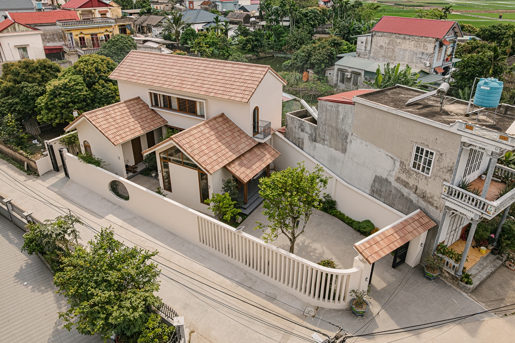 Dù nằm ngay giao lộ đông đúc nhưng ngôi nhà vẫn giữ được những những khoảng lặng đáng quý nhờ sân vườn bao bọc