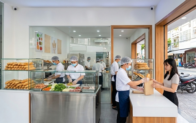 Người bán bánh mì phải mang khẩu trang, đội mũ, dùng bao tay hoặc kẹp gắp thực phẩm (Ảnh minh họa: N.Q tạo từ GM)