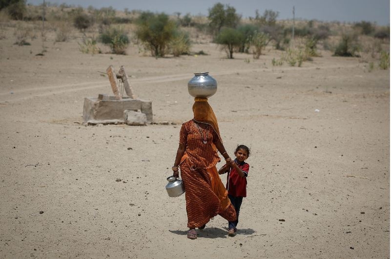 Một người phụ nữ đi lấy nước tại vùng sa mạc ở Barmer, bang Rajasthan (Ấn Độ). Ảnh: Reuters