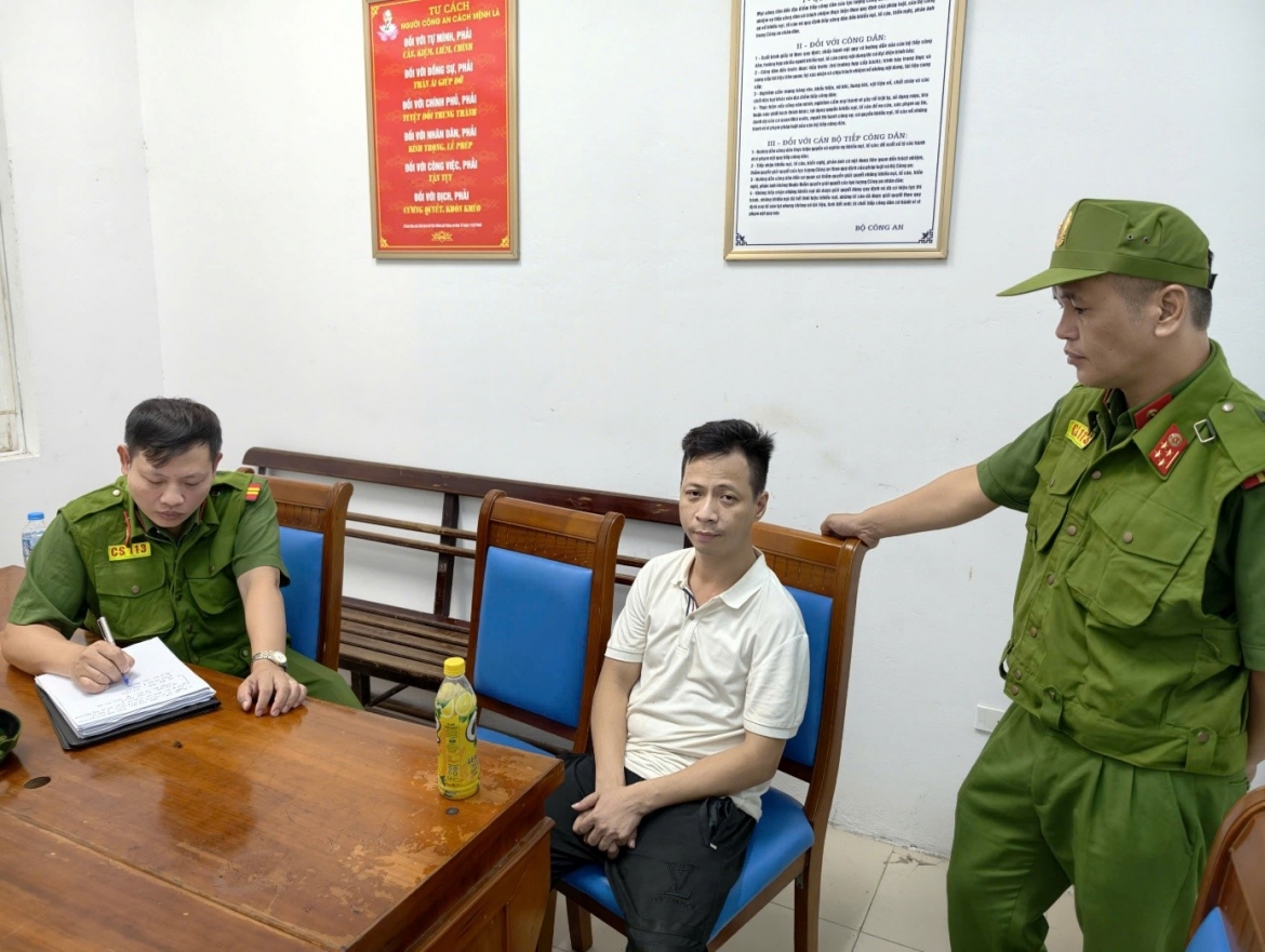 Nguyễn Đức Hiếu (áo trắng) tại cơ quan công an.