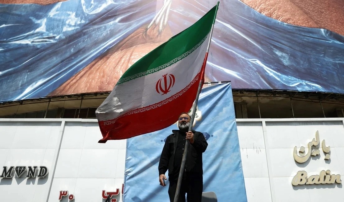 Người dân Iran cầm quốc kỳ tại Tehran. Ảnh: Reuters