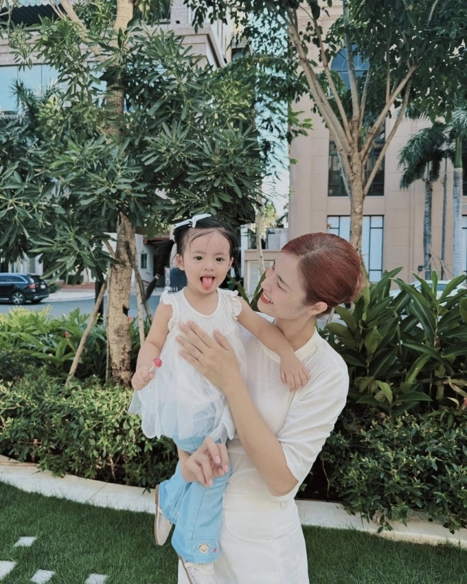 Đông Nhi nô đùa bên con gái nhỏ trong lúc chờ con gái lớn tan học.