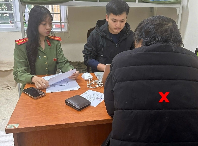 Cán bộ phòng An ninh chính trị nội bộ (PA03 - Công an TP Hà Nội) xử lý người đàn ông tung tin giả trên mạng xã hội Facebook (dấu X).