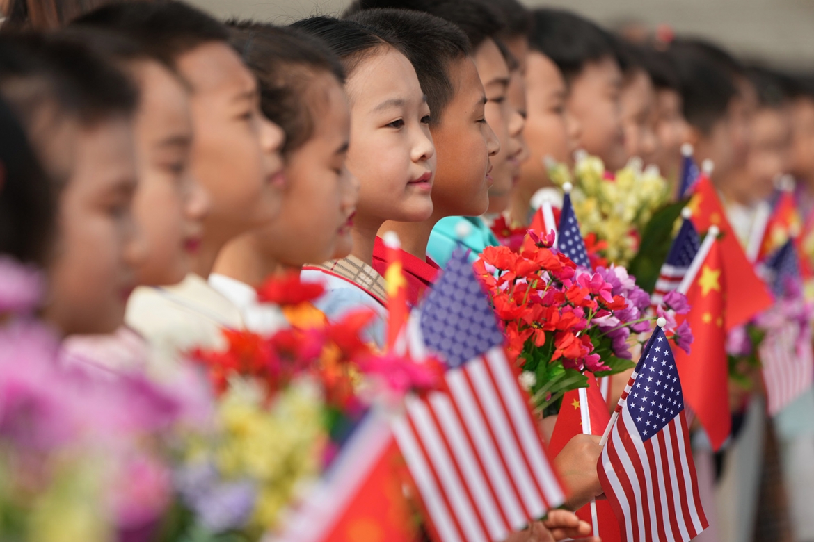 Các em nhỏ cầm cờ Mỹ và Trung Quốc chào đón Tổng thống Mỹ Donald Trump. Ảnh: AP