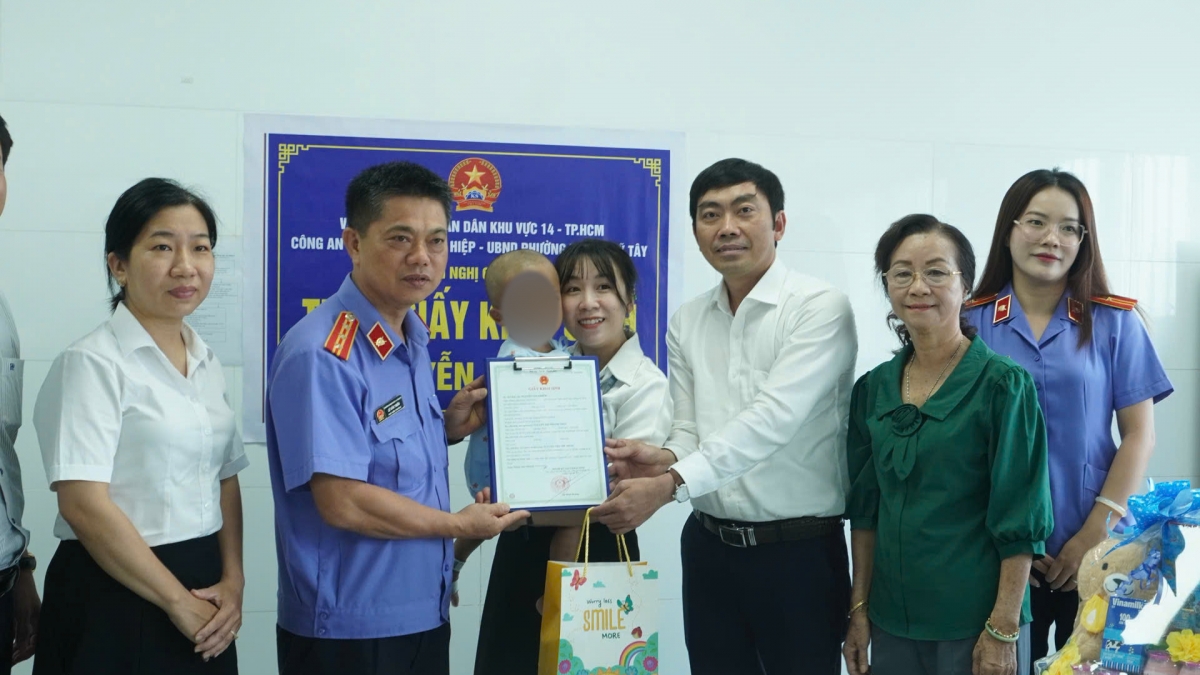 Đoàn công tác liên ngành trao giấy khai sinh cho bé (Ảnh: BVCC)