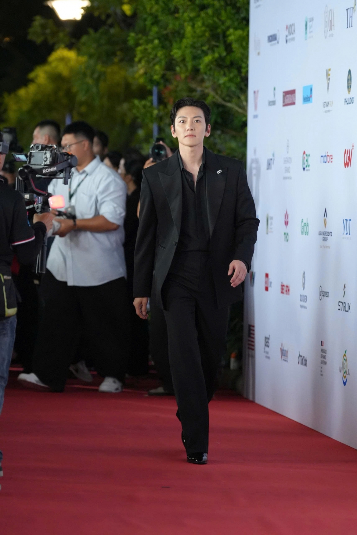 Ji Chang Wook thu hút mọi ánh nhìn với bộ suit đen tối giản nhưng sang trọng. Nam diễn viên lựa chọn phong cách lịch lãm cùng mái tóc vuốt gọn, gương mặt rạng rỡ và nụ cười thân thiện.