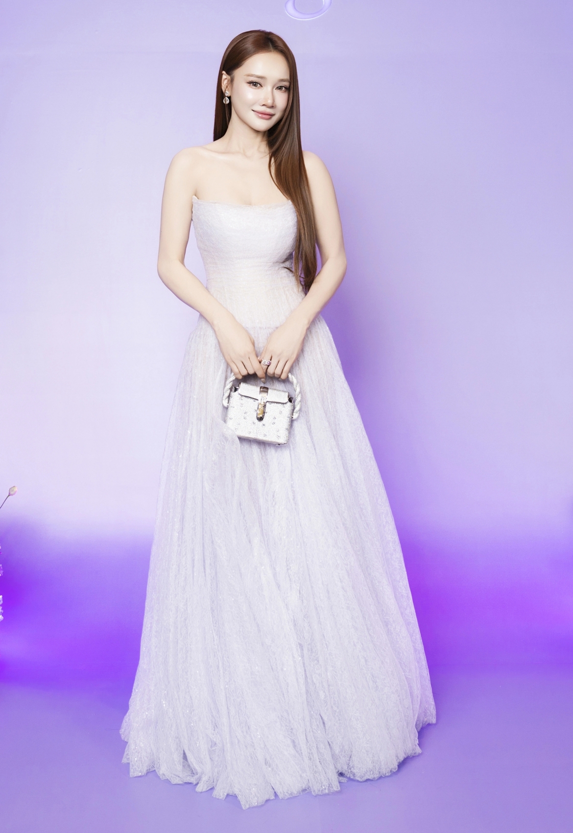 Nhã Phương diện đầm quây gam tím pastel, phối túi xách mini hiệu Dolce &amp; Gabbana tại một sự kiện. Cô sinh con thứ ba gần bốn tháng, lấy lại vóc dáng nhờ chăm chạy bộ, yoga và chế độ ăn nghiêm ngặt.