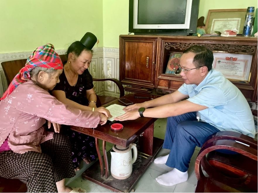 Cán bộ Trung tâm phục vụ hành chính công xã Sông Mã hỗ trợ người dân thực hiện thủ tục hành chính tại nhà