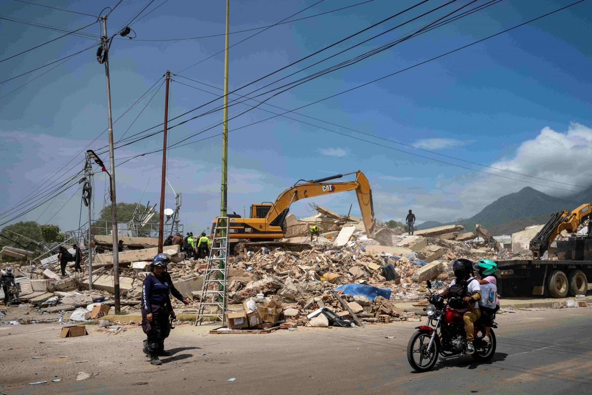 Các loại máy móc hạng nặng đang được chính quyền Venezuela huy động nhằm đẩy nhanh việc tìm kiếm và dọn dẹp đống đổ nát. Trong ảnh là máy xúc đang tham gia việc phá dỡ một tòa nhà bị sập sau động đất, tại Caraballeda, bang La Guaira.