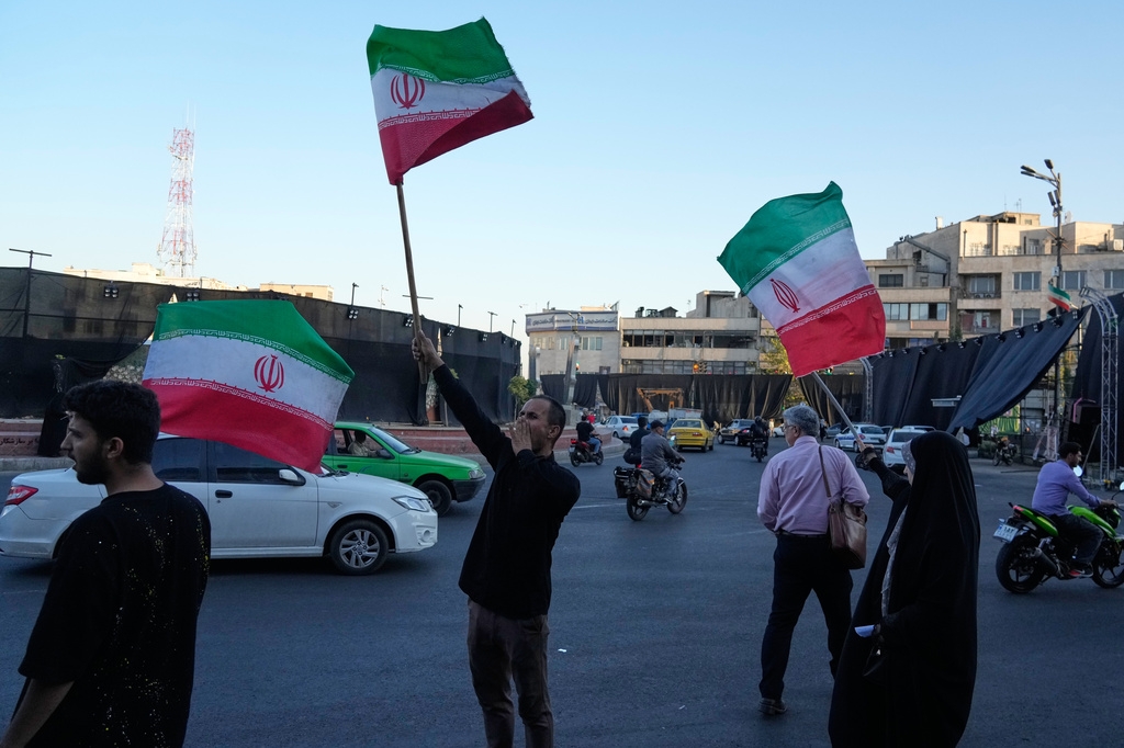 Người dân Iran vẫy cờ và hô khẩu hiểu phản đối Mỹ tại Quảng trường Cách mạng Hồi giáo Iran ở thủ đô Tehran (Ảnh: AP)