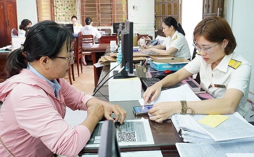 Cán bộ Thuế hướng dẫn người dân khai thuế. Ảnh: baodautu.vn