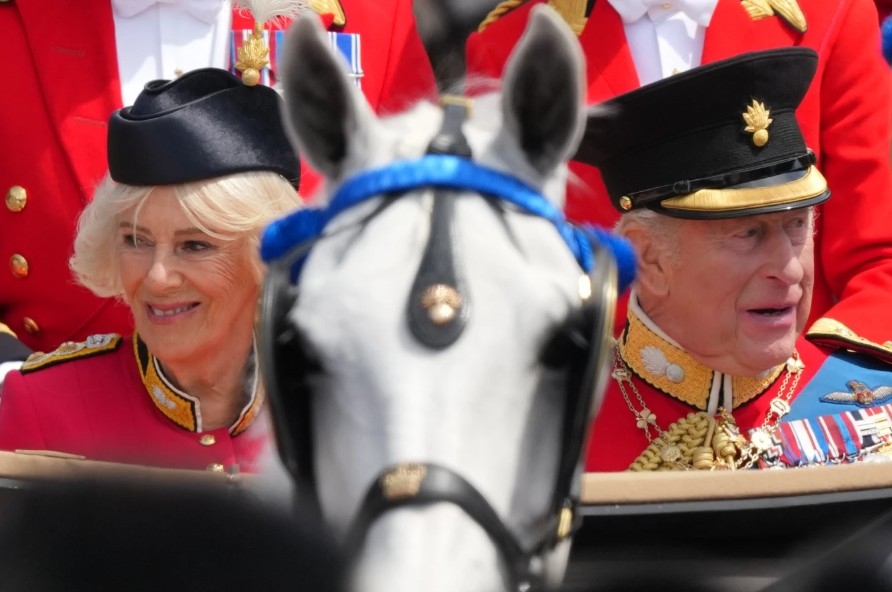 Vua Charles III và Hoàng hậu Camilla nhìn ra đám đông đứng dọc đại lộ The Mall khi trở về Cung điện Buckingham sau lễ diễu hành Trooping the Colour.