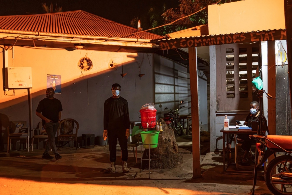 Một nhân viên an ninh đứng chờ bên ngoài, cạnh khu vực rửa tay, tại lối vào hộp đêm Miterants ở Bunia, CHDC Congo.