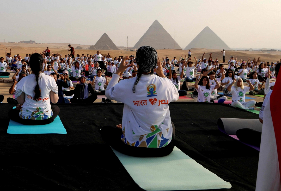 Yoga là môn luyện tập thể chất, tinh thần và tâm linh, ra đời cách đây 5.000 năm ở Ấn Độ và hiện nay đã phổ biến khắp thế giới. Ý tưởng chọn một ngày trong năm làm ngày tôn vinh yoga trên toàn thế giới xuất hiện từ lâu. Tháng 12/2014, Chính phủ của Thủ tướng Ấn Độ Narendra Modi đã vận động thành công Liên hợp quốc chọn ra một ngày để ghi nhận và quảng bá lợi ích của môn thể thao này. Trong ảnh là việc thực hành yoga trong ngày 21/6 trước kim tự tháp Giza nổi tiếng tại Ai Cập (Ảnh: Reuters)