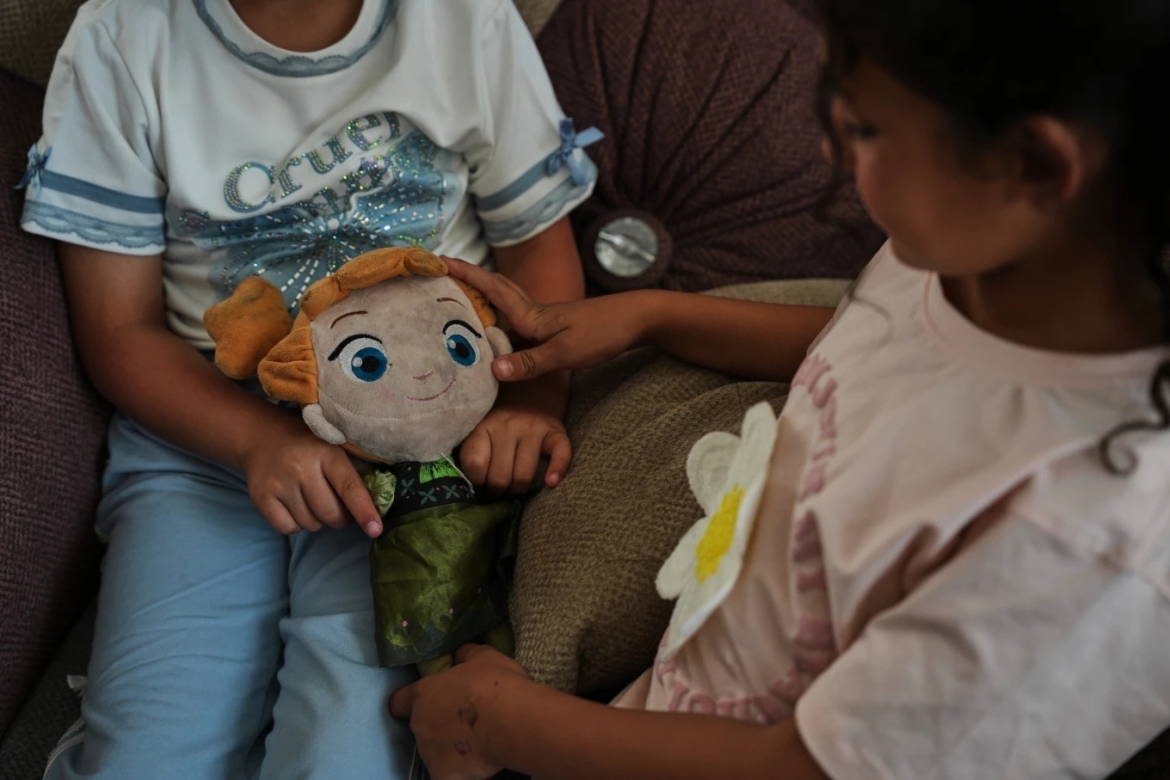 Hai chị em Nabila và Basmala Al-Kafarna chơi cùng búp bê tại nhà riêng ở thành phố Gaza ngày 31/5/2026. Cha mẹ các em thiệt mạng trong một cuộc không kích hồi tháng 4/2025.