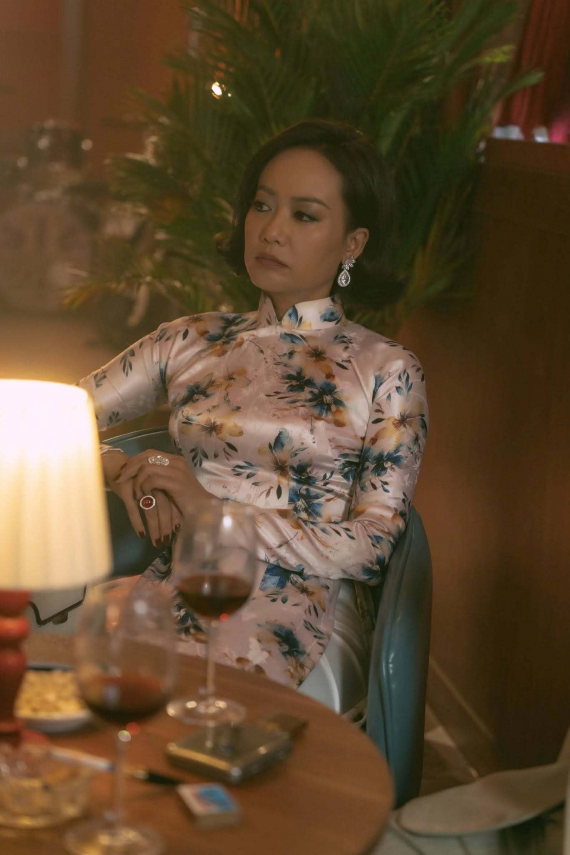 Hồng Ánh trong vai Madame Sắc với áo dài cổ điển, gam màu trầm, thần thái quyền lực