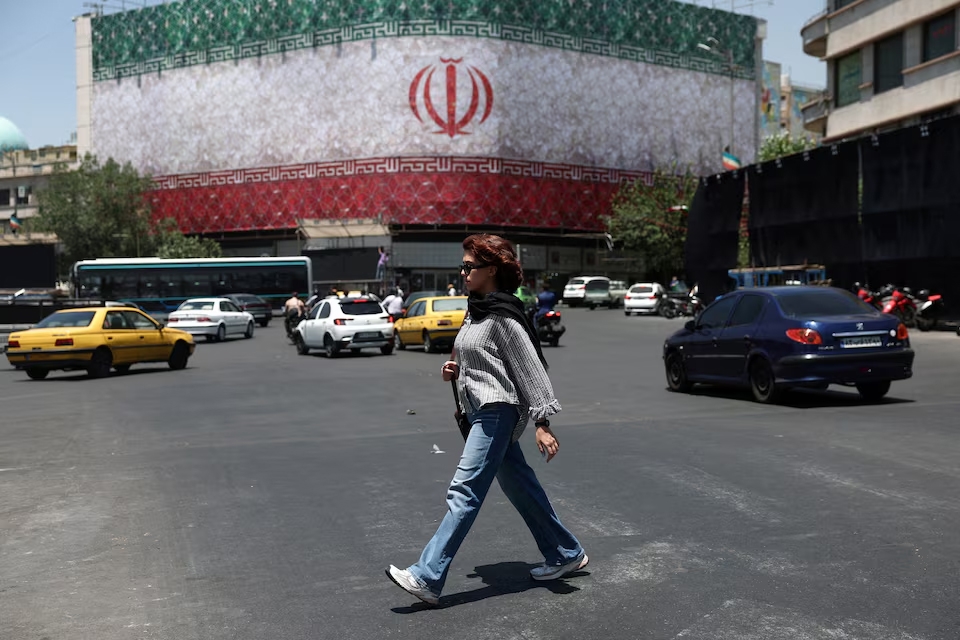 Một người phụ nữ đi bộ trên đường phố ở Tehran, Iran, ngày 14/6/2026. Ảnh: WANA/Reuters