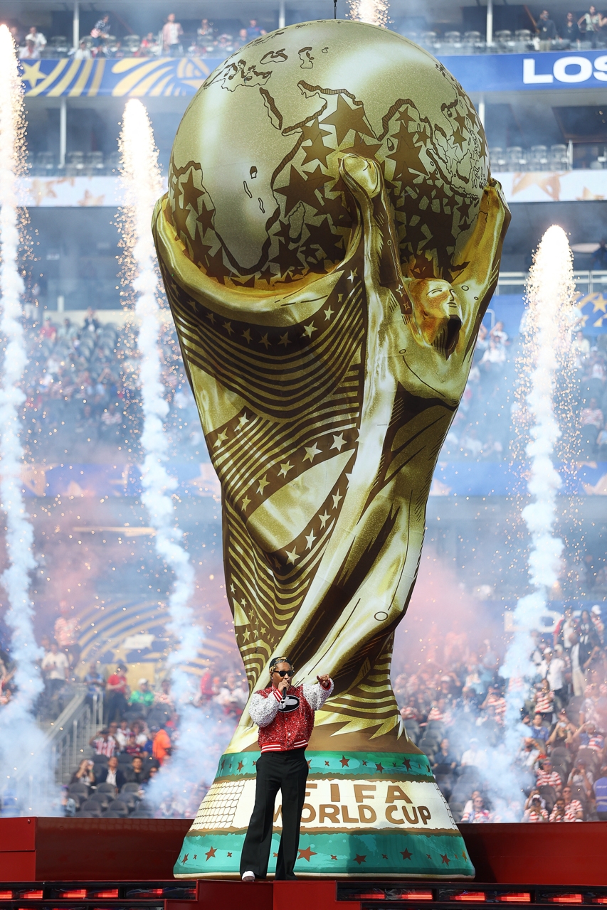 Các nghệ sĩ trình diễn dưới hình ảnh chiếc cúp vàng World Cup (Ảnh: Reuters)