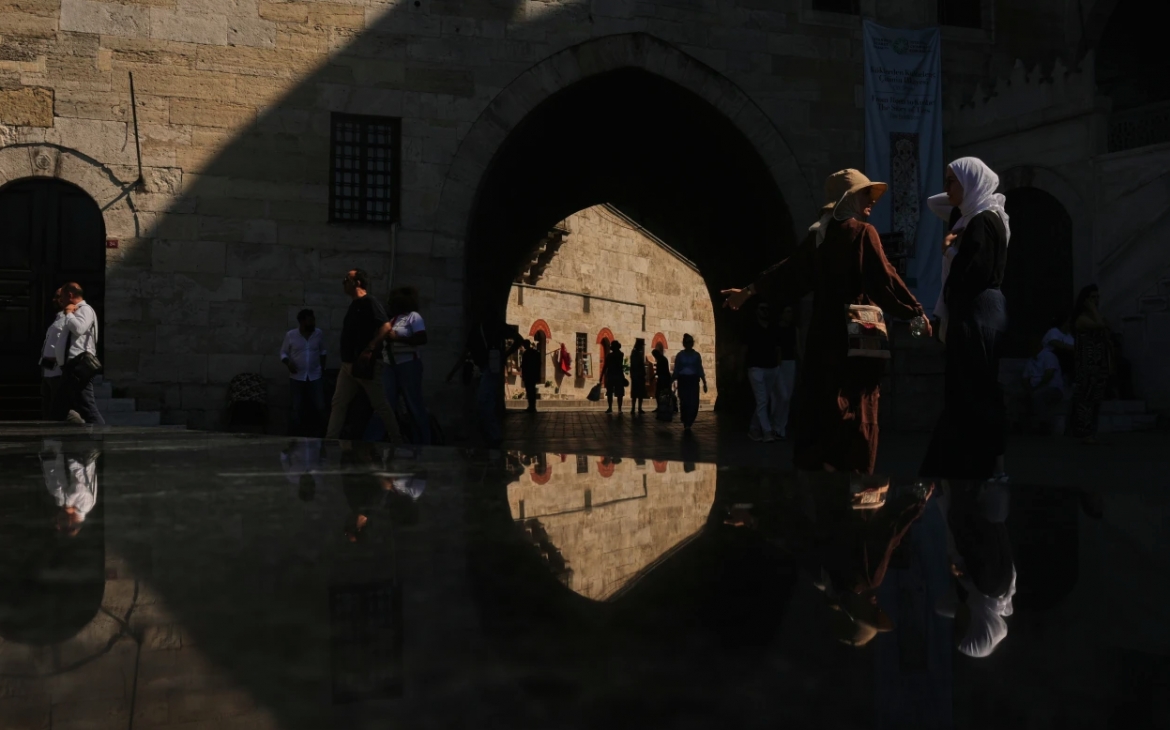 Người dân đi bộ dưới bóng râm tại nhà thờ Hồi giáo Yeni ở Istanbul, Thổ Nhĩ Kỳ, ngày 22/6/2026.