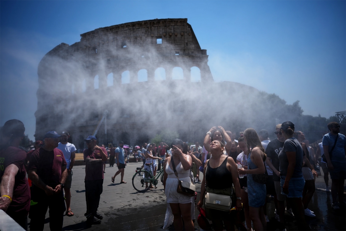 Người dân tìm cách giải nhiệt trước vòi phun nước do chính quyền thành phố Rome (Italy) bố trí để giúp du khách tham quan Đấu trường La Mã bớt nóng bức khi nhiệt độ đạt mức cao kỷ lục.