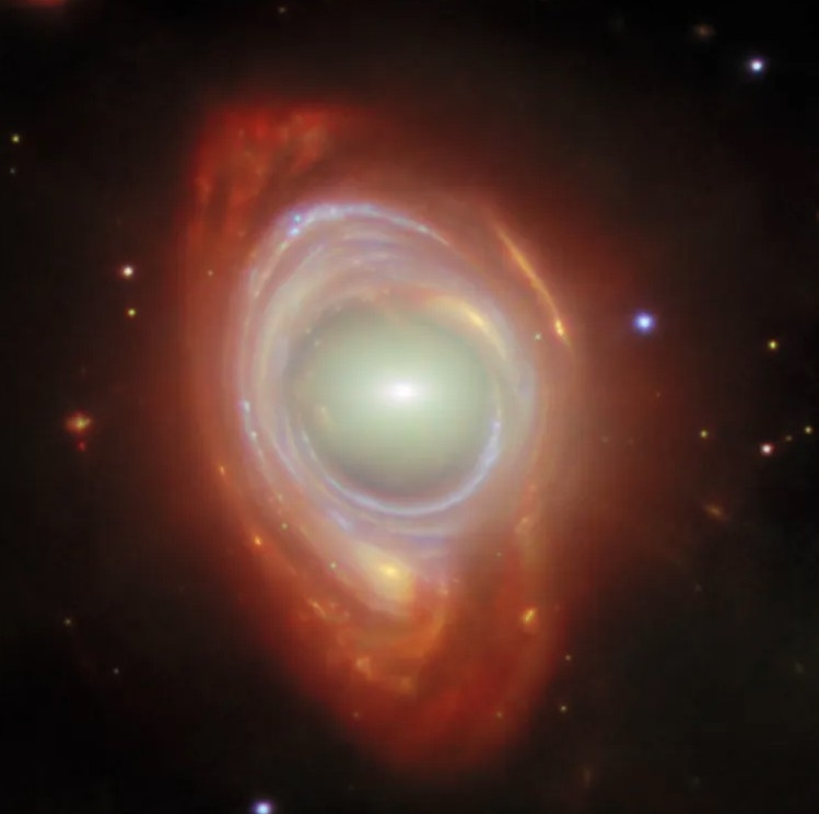Bức ảnh do JWST ghi lại cho thấy một hiện tượng vũ trụ hiếm gặp mang tên Vòng Einstein. Một thiên hà xoắn ốc ở rất xa bị biến dạng thành vòng sáng gần như hoàn chỉnh bao quanh một thiên hà elip ở gần hơn. Dù trông giống một thiên thể duy nhất, thực tế đây là hai thiên hà riêng biệt nằm gần như thẳng hàng hoàn hảo theo hướng quan sát từ Trái Đất. Chính sự sắp xếp đặc biệt này đã tạo nên hiệu ứng thấu kính hấp dẫn ngoạn mục.