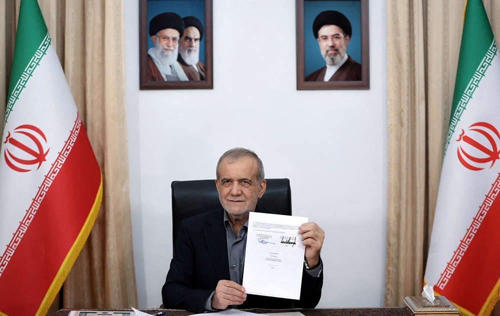 Tổng thống Iran Masoud Pezeshkian ký văn kiện Biên bản ghi nhớ với Mỹ tại Tehran. Ảnh: Reuters