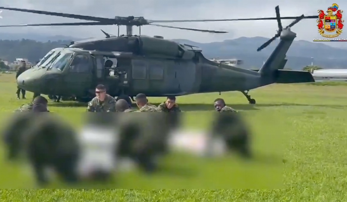 Máy bay trực thăng và binh sĩ Colombia trước các thi thể “khủng bố” (bị che mờ). Ảnh: Fuerzas.